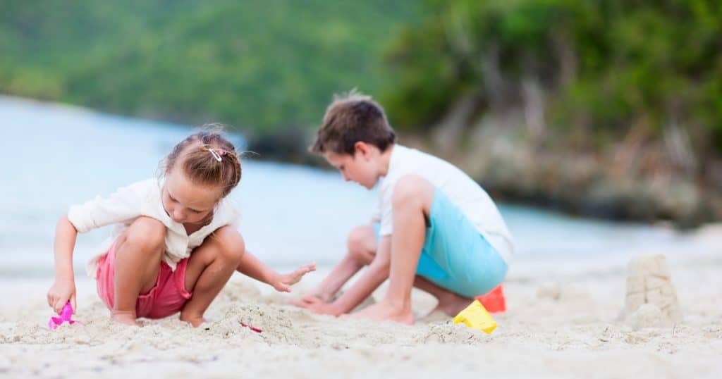 Two kids playing on a beach seperately https://www.autismparentingmagazine.com/parallel-play-in-autism/