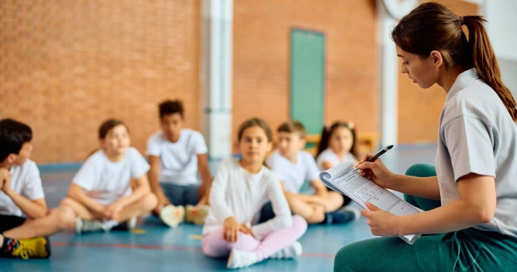 Physical education teacher taking notes https://www.autismparentingmagazine.com/iep-goals-for-autism/