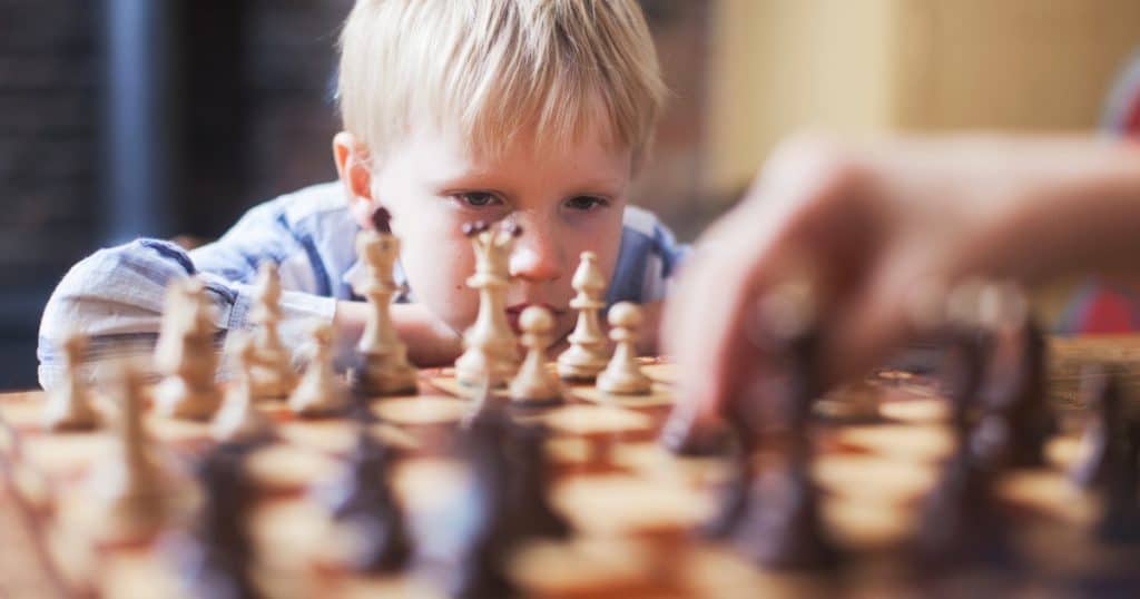 Little boy focused playing chess https://www.autismparentingmagazine.com/autism-monotropism/