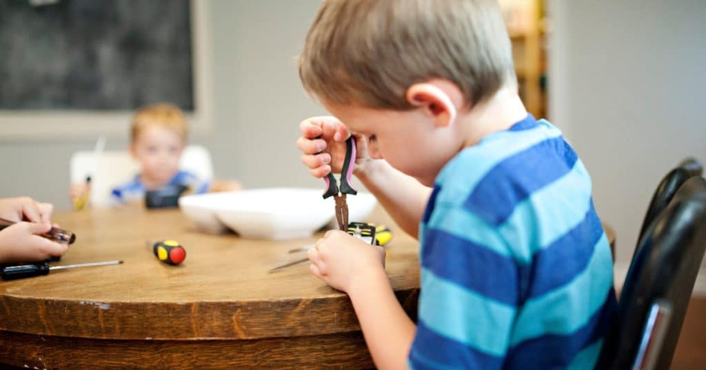 A young boy focusing on fixing his toy https://www.autismparentingmagazine.com/autism-and-perfectionism/