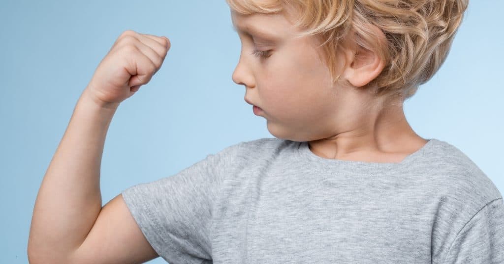 Supporting autistic individuals with low muscle tone A boy checking his arm muscles https://www.autismparentingmagazine.com/low-muscle-tone-and-autism/